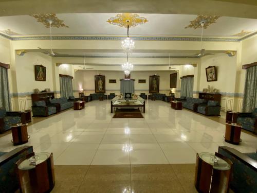 ein großes Wohnzimmer mit Sofas und einem Kronleuchter in der Unterkunft Dowlat Villas Palace-The Heritage in Himatnagar