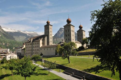 a building with three towers on top of a park at Schlosshotel - Self Check-In Hotel in Brig