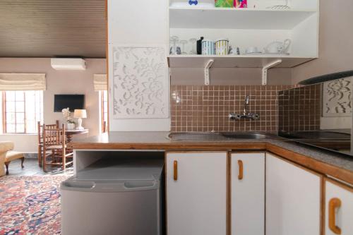 a kitchen with white cabinets and a counter top at Boord Guest House in Stellenbosch