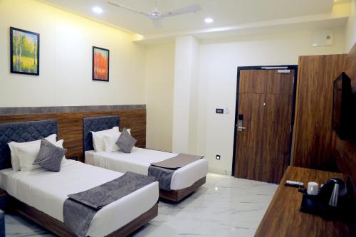 a hotel room with two beds and a wooden door at Suvin Residency with Rooftop Swimming Pool in Udaipur