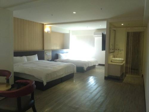 a hotel room with two beds and a bathroom at Dengfeng Milan Business Hotel in Huwei