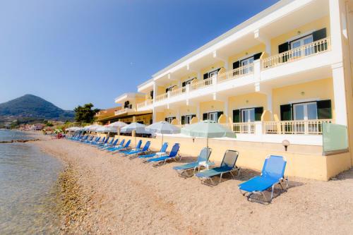 una fila di sedie sulla spiaggia di fronte a un hotel di Hotel Rossis a Mesongi
