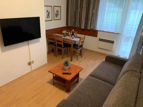 a living room with a couch and a table at Apartmán B13 Tatran Donovaly in Donovaly