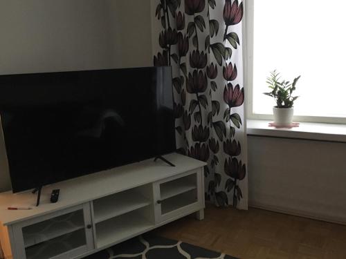 a living room with a flat screen tv on a white cabinet at Viihtyisä asunto keskustassa palvelujen lähellä in Heinola
