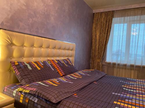 a bedroom with a bed with a yellow headboard at Kharkiv Center Apartment on Hoholya Str, Poetry square in Kharkiv