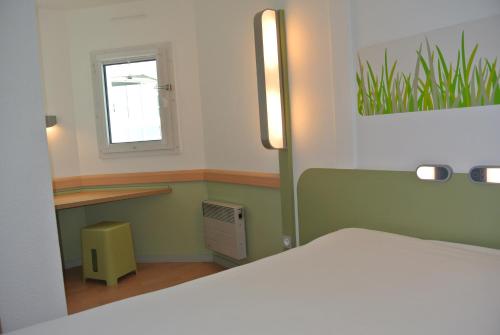 a bedroom with a white bed and a window at ibis budget Chambéry Sud Challes Les Eaux in Challes-les-Eaux