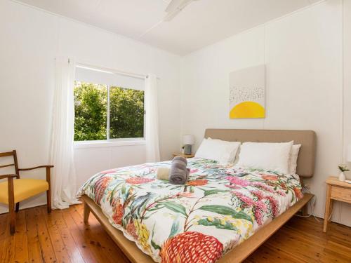 克拉龙Nest I Pet Friendly I 2 Min Walk to Beach的卧室配有一张床、一条被子和一扇窗户