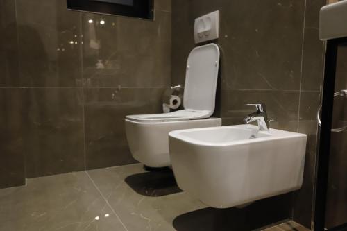 a bathroom with a white toilet and a sink at Admiral Hotel in Elbasan