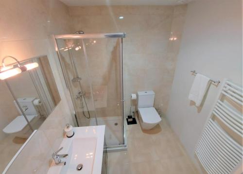 a bathroom with a shower and a sink and a toilet at Anjo33 Flats in Braga