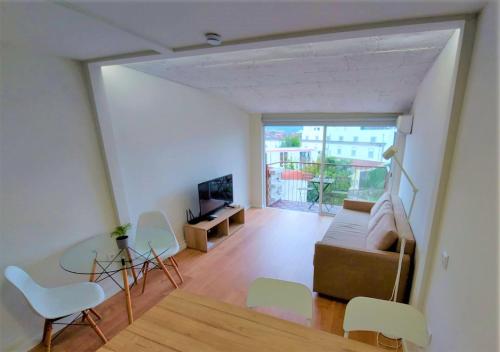 a living room with a couch and a table and chairs at Anjo33 Flats in Braga