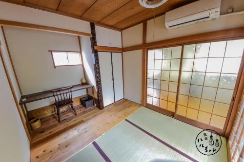 una habitación con reloj y silla en una habitación en ベーグル屋企画の民泊 ハルちゃん l Guest House Produced By Haruchan Bagel Shop 制限有り無料駐車場付き, en Zushi