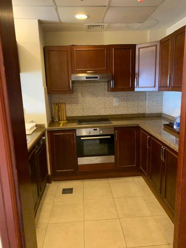 a kitchen with wooden cabinets and a stove top oven at B city view in King Abdullah Economic City