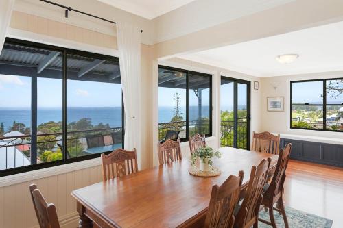 a dining room with a table and chairs and windows at Heritage House Motel & Units in Eden