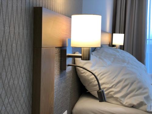 a lamp on a wall next to a bed at Apartman Lucid C207 in Smokovce