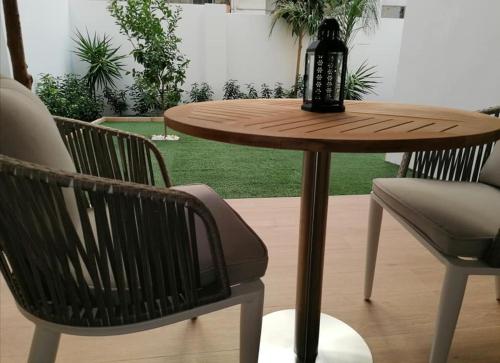 a wooden table with two chairs and a table with a bottle on it at Lux Suite in Taranto