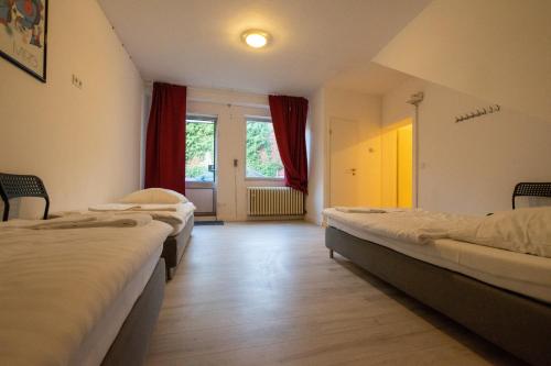 Zimmer mit 3 Betten und einem Fenster in der Unterkunft Spacious House in Düsseldorf