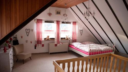 a attic bedroom with a bed and a window at Campo Allegre Duplex Ferienwohnung in Windeck