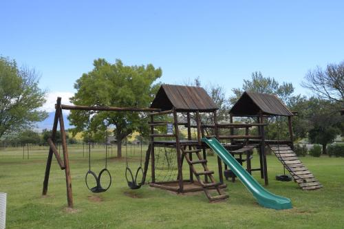 a playground with a slide and a swing set at ATKV Drakensville in Bergville