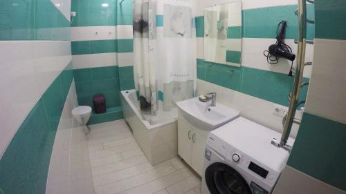 La salle de bains est pourvue d'un lavabo et d'un lave-linge. dans l'établissement Просторная квартира в Одессе, à Odessa