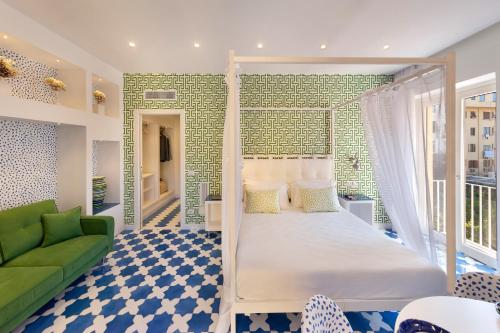 a bedroom with a bed and a green couch at Luxury&Romantic Apartment with Balcony in Sorrento in Sorrento