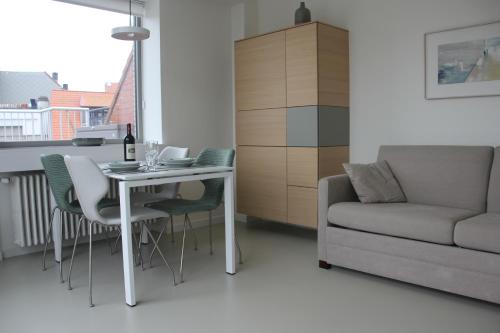 uma sala de estar com uma mesa e um sofá em Penthouse Sun Corner Knokke em Knokke-Heist