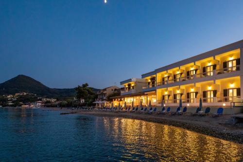 a hotel on the shore of the water at night at Hotel Rossis in Mesongi