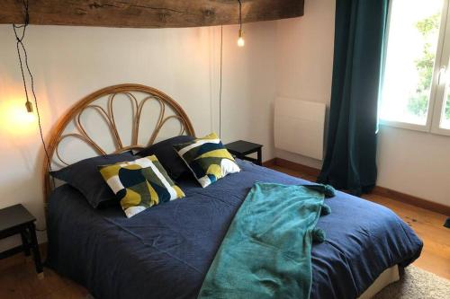 um quarto com uma cama com lençóis e almofadas azuis em Gîte de Ker Val em Étauliers