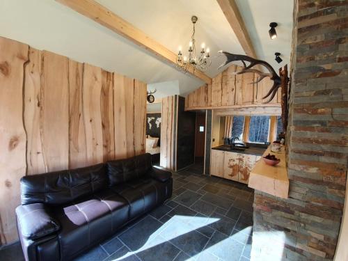 salon ze skórzaną kanapą i ceglaną ścianą w obiekcie Alpin Lodge w mieście Azuga