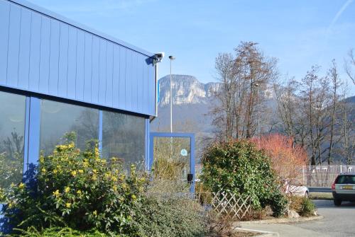 a glass building with a view of a mountain at ibis budget Chambéry Sud Challes Les Eaux in Challes-les-Eaux