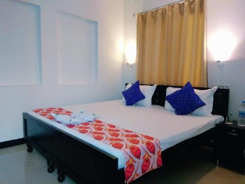 a bedroom with a large bed with blue and red pillows at Amritchandra homestay and hostel in Udaipur