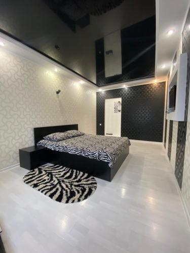 ein Schlafzimmer mit einem Bett und einem Teppich auf dem Boden in der Unterkunft Lux City Center in Kvartal 95 in Krywyj Rih