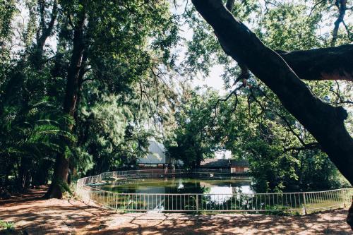 a pond in a park with a fence around it at ATKV Buffelspoort in Rustenburg