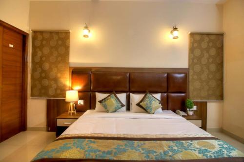 1 dormitorio con 1 cama grande y 2 lámparas en Atithi Suites - An AHG Hotel, en Greater Noida