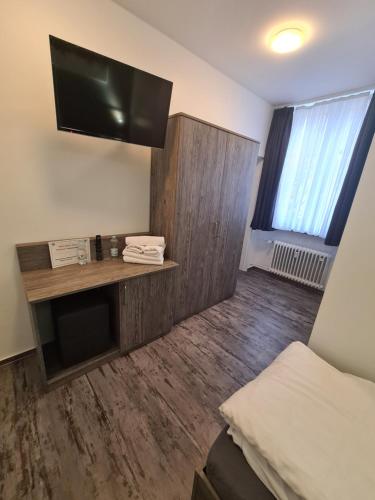 a room with a bed and a flat screen tv at Pension Zwei A in Leverkusen