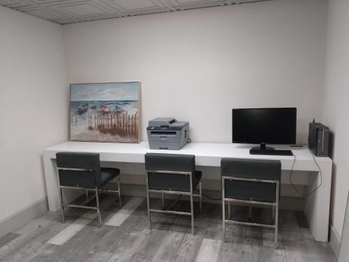 a desk with a computer and chairs in a room at Wingate by Wyndham Atlanta Galleria/ Ballpark in Atlanta
