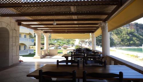 a patio with tables and chairs and a view of the ocean at Castle Hotel in Himare