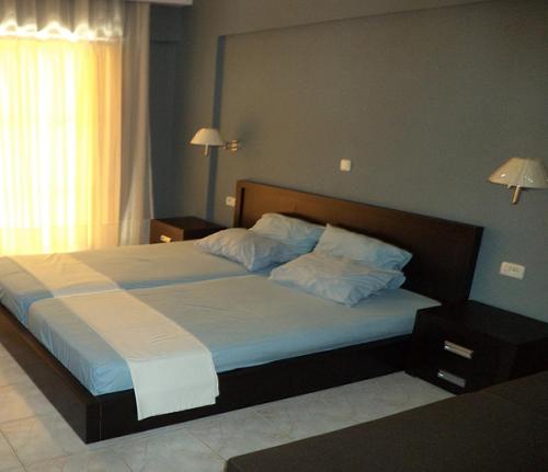 1 dormitorio con 1 cama grande con sábanas y almohadas blancas en Castle Hotel, en Himare
