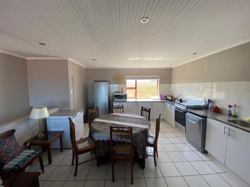 uma cozinha com mesa e cadeiras num quarto em Relax & Recharge em Boggomsbaai