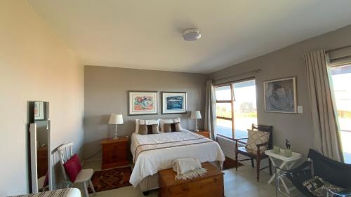 a bedroom with a bed and a large window at Relax & Recharge in Boggomsbaai