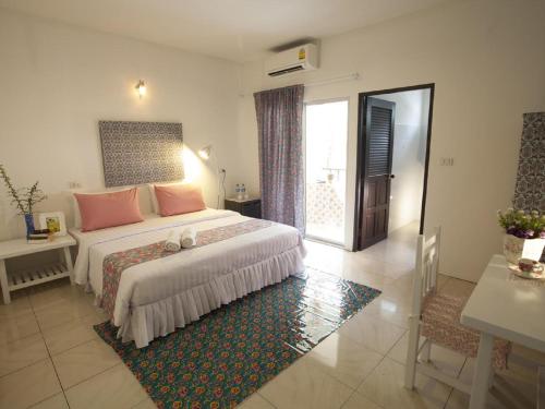 a bedroom with a large bed with pink pillows at Les Fleurs House in Khao Lak