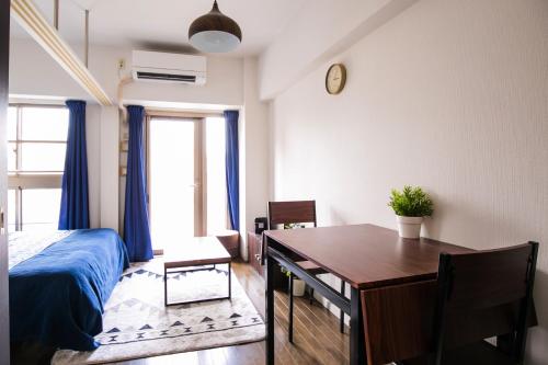 a bedroom with a table and a bed and a dining room at Yakuin apartment in Fukuoka