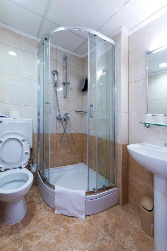 a bathroom with a shower and a toilet and a sink at Hotel Perla in Dubrovnik