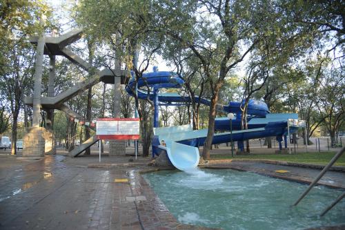 un tobogán azul en un parque con una piscina de agua en ATKV Eiland Spa en Letsitele