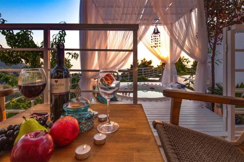Highclere Hotel and Spa في فاراليا: طاولة خشبية مع كأسين من النبيذ والفواكه