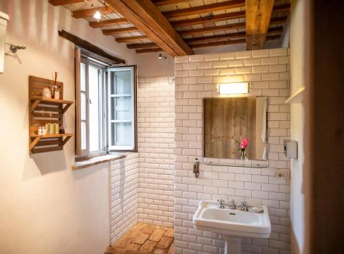 a white bathroom with a sink and a window at Casa San Ruffino in Montegiorgio
