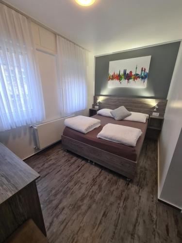 a bedroom with two beds and a painting on the wall at Pension Zwei A in Leverkusen