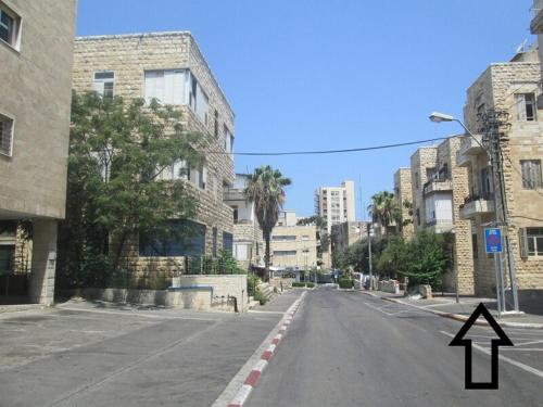 an empty street in a city with a arrow pointing up at Apartments COMFY - for a quiet family holiday in Haifa