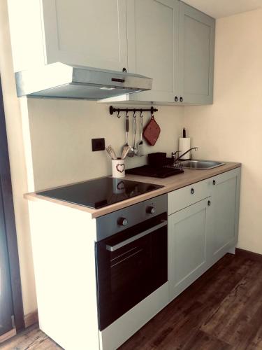 a kitchen with white cabinets and a black dishwasher at Hotel Piccolo Chalet in Claviere