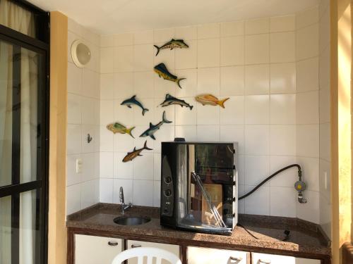 a kitchen with a counter with birds on the wall at Riviera Green in Riviera de São Lourenço