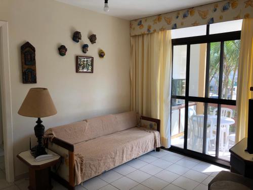 ein Wohnzimmer mit einem Sofa und einem großen Fenster in der Unterkunft Riviera Green in Riviera de São Lourenço
